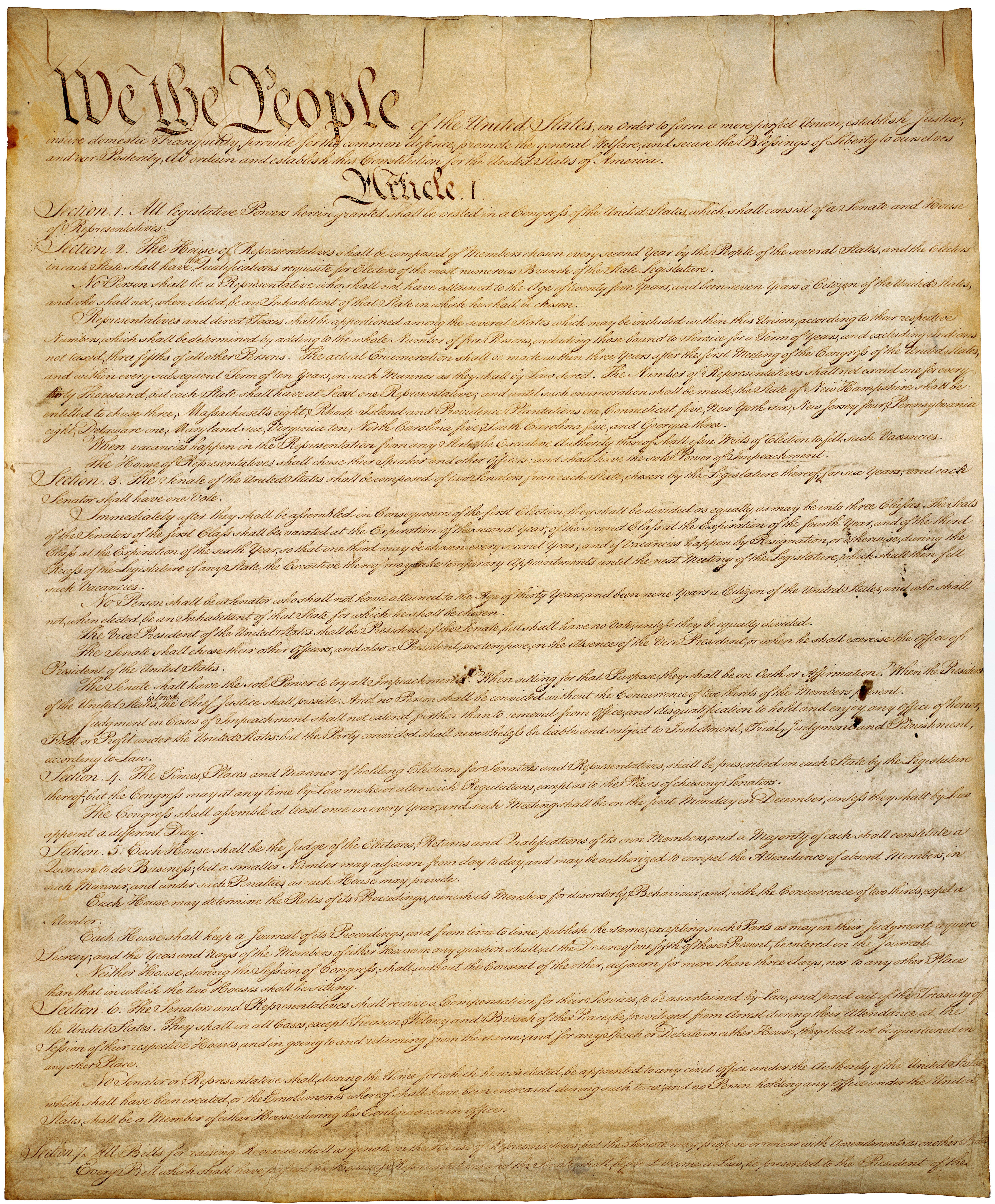 An image of the original United States Constitution on yellowed parchment paper. The words "We the People" and "Article 1" can be read clearly, followed by paragraphs of cursive script.