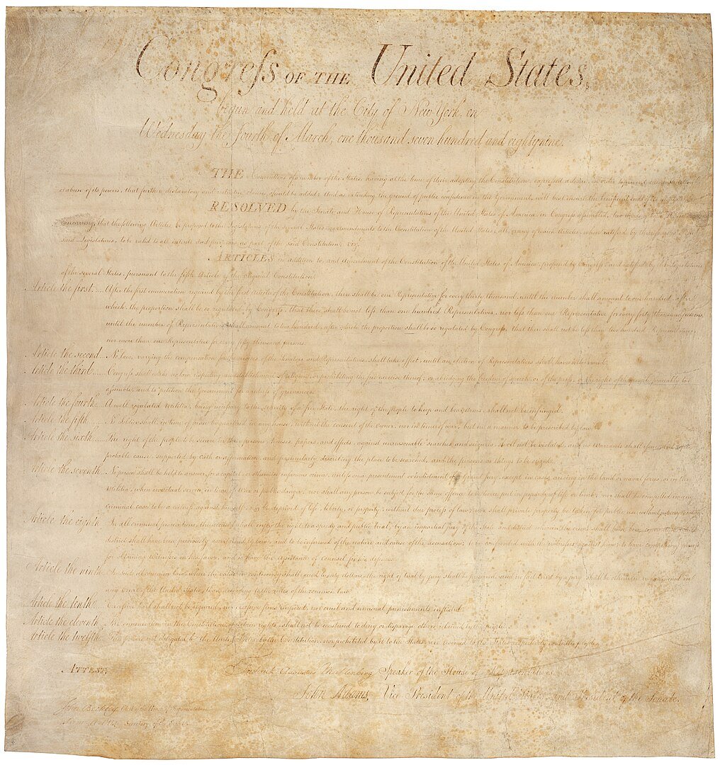 An image of the Bill of Rights on yellowed parchment paper. The words "Congress of the United States" can be read clearly at the top, followed by faded cursive script.