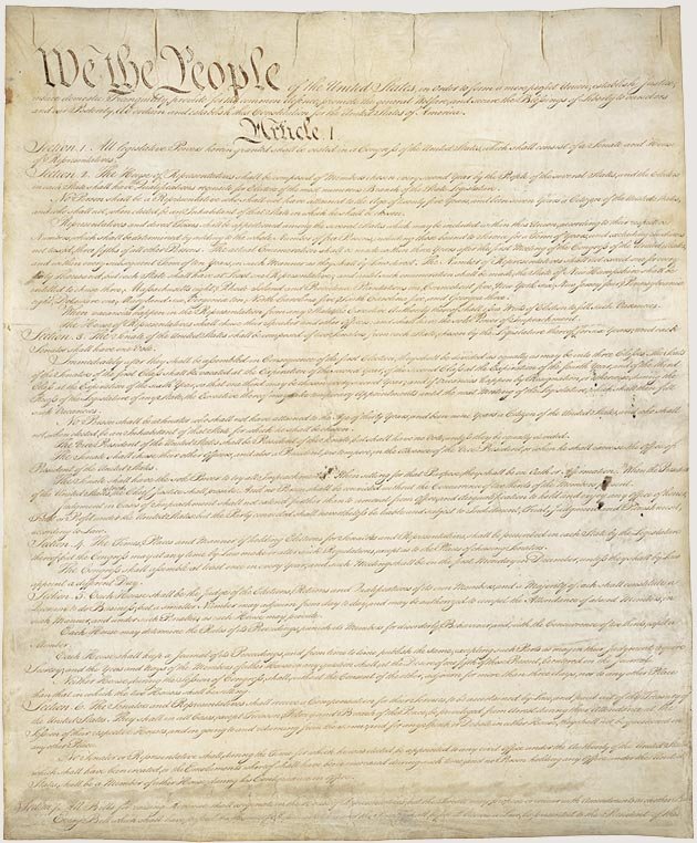 An image of the original United States Constitution on yellowed parchment paper. The words, "We the People" and "Article 1" can be read clearly.